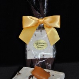 Caramel Pecan Bark in a clear and brown cello bag with a brown satin bow