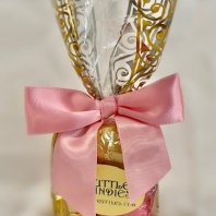 6 Pc Peanut Bruttle Bag.  Bruttles are wrapped in pink and brown foil and put into a brown cello bag with pink polka dots and closed with a pink satin ribbon.