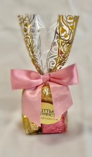 6 Pc Peanut Bruttle Bag.  Bruttles are wrapped in pink and brown foil and put into a brown cello bag with pink polka dots and closed with a pink satin ribbon.